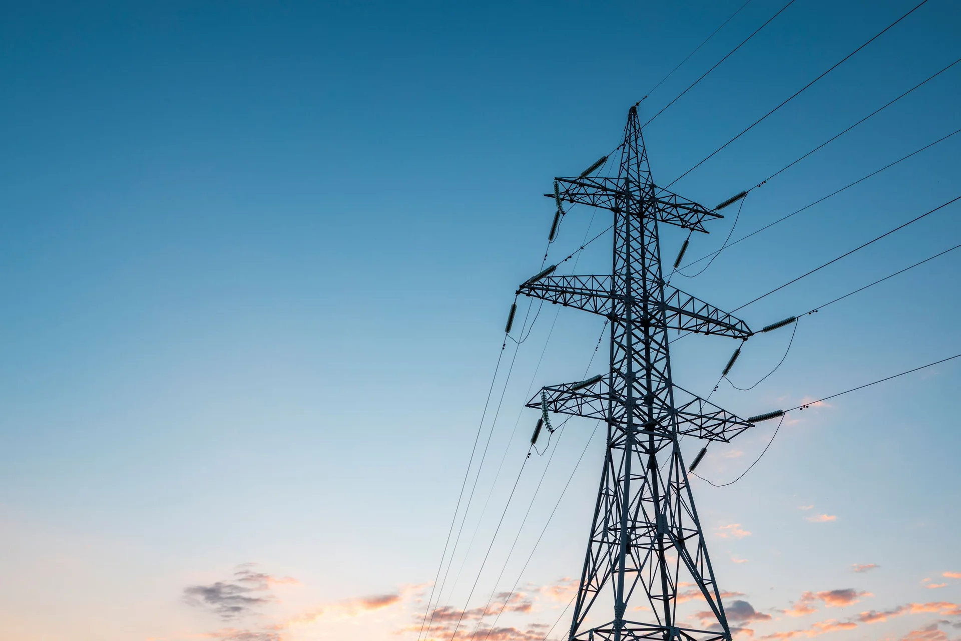 Electricity transmission tower beneath a clear evening sky